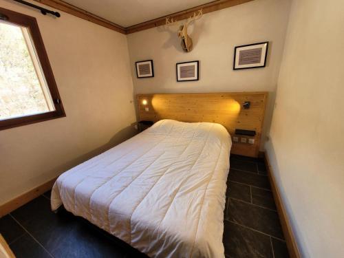 ein Schlafzimmer mit einem Bett in einem Zimmer mit einem Fenster in der Unterkunft Résidence Le Criterium - Résidence Le Critérium 3Chalet E Appartement 5 MAE-7731 in Lanslebourg-Mont-Cenis