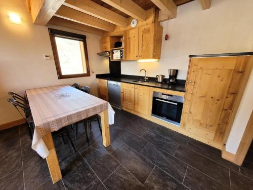 une cuisine avec des armoires en bois et une table en bois dans l'établissement Résidence Le Criterium - 3 Pièces pour 6 Personnes MAE-7751, à Lanslebourg-Mont-Cenis