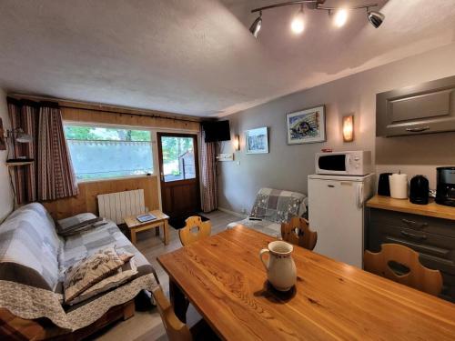 une cuisine avec une table et une salle à manger dans l'établissement Résidence Foret-erable - Petit 2 pièces chaleureux et bien équipé MAE-7781, à Bonneval-sur-Arc