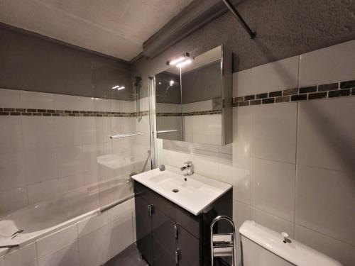a bathroom with a sink and a mirror and a tub at Résidence Foret-erable - Petit 2 pièces chaleureux et bien équipé MAE-7781 in Bonneval-sur-Arc