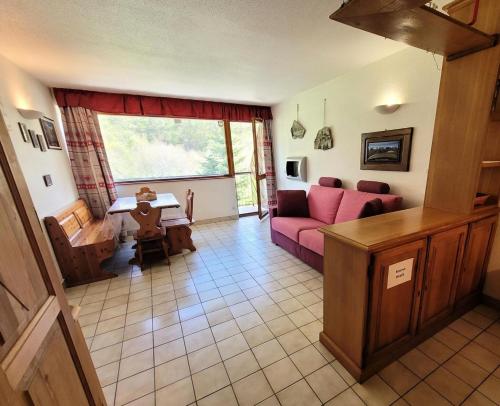 un salon avec un canapé rose et une table dans l'établissement Résidence Le Soliet I - Studio pour 4 Personnes MAE-7821, à Bessans