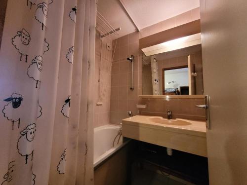 une salle de bain avec un lavabo et un rideau de douche dans l'établissement Résidence Le Soliet I - Studio pour 4 Personnes MAE-7821, à Bessans