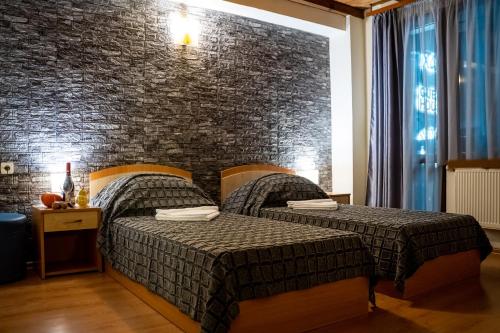 two beds in a room with a brick wall at Matsurev Han in Bansko