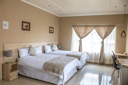 Un dormitorio con dos camas y una ventana. en Unleashed guesthouse, en Johannesburgo