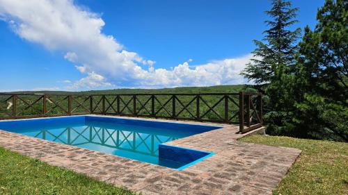 una piscina en el césped junto a una valla en Casa planta alta 2 dormitorios, en Valle Hermoso
