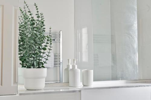 a white window sill with a plant and two candles at Long Stays Angel Apartment with Terrace in London