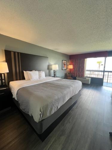a large bed in a hotel room with two lamps at Quality Inn & Suites Gulf Breeze Bayside near Pensacola Beach in Gulf Breeze