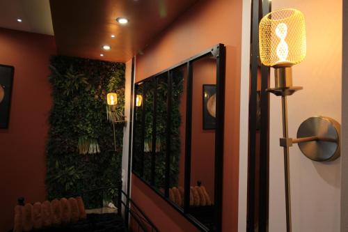 a room with a large mirror with plants on the wall at Luxury Studio, Rez de chaussée, Parking privé vidéo surveillance, Canapé haute qualité convertible couchage 2 personnes, Centre Ville proche, Restaurant, boulangerie 2 minutes à pied, Terrasse - 800mètre carré de terrain - Géré par Presta-Zen'Services in Verdun