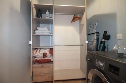 a closet with a white refrigerator in a kitchen at Luxury Studio, Rez de chaussée, Parking privé vidéo surveillance, Canapé haute qualité convertible couchage 2 personnes, Centre Ville proche, Restaurant, boulangerie 2 minutes à pied, Terrasse - 800mètre carré de terrain - Géré par Presta-Zen'Services in Verdun