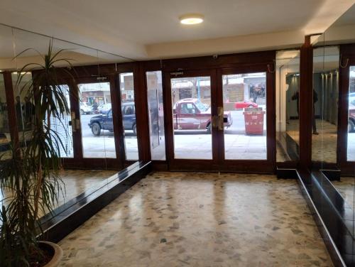 an empty lobby with glass doors and a plant at Edificio Queirolo in Mar del Plata