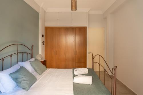 a bedroom with a bed with two towels on it at Veranda at Patras Center Apartment in Patra