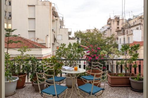 a balcony with a table and chairs and plants at Veranda at Patras Center Apartment in Patra