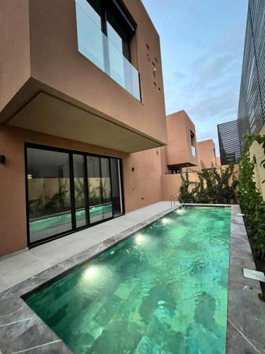a swimming pool in front of a house at Villa Tagana in Marrakesh