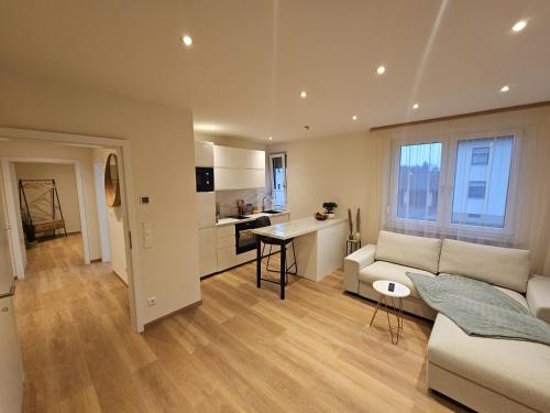 a living room with a couch and a kitchen at Zu Gast im Goldparadies, Ferienwohnung in Sulzbach-Rosenberg