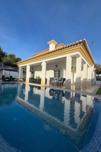 a large swimming pool in front of a house at Villa Bonita Guesthouse Albufeira Old Town in Albufeira