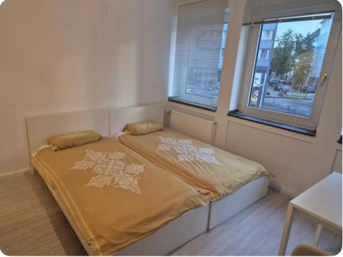 a bed in a room with two windows at Schicke Wohnung, Innenstadt, beliebtes Viertel in Cologne