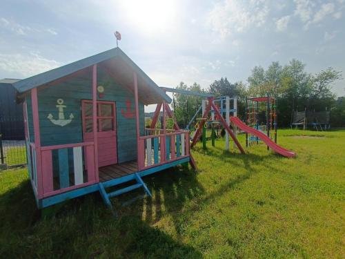 un pequeño parque infantil con una estructura de juegos en un campo en Domki Halo Morze, en Jastrzębia Góra