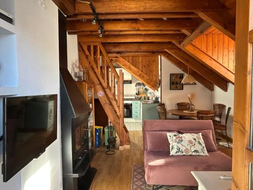 a living room with a couch and wooden ceilings at El rincón de Benás in Anciles