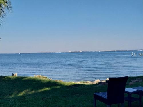 two chairs sitting on the grass near a body of water at Quality Inn & Suites Gulf Breeze Bayside near Pensacola Beach in Gulf Breeze
