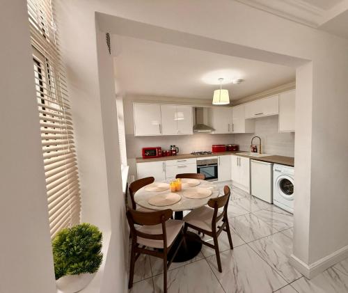 a kitchen with a table and chairs in a room at Cozy 3 bed house in Coventry