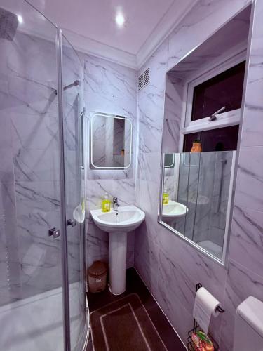 a white bathroom with a sink and a shower at Cozy 3 bed house in Coventry