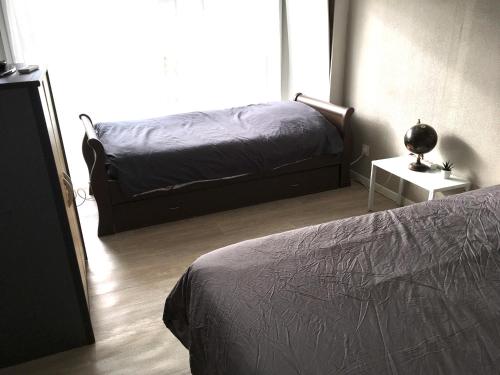 une chambre avec un lit et une table avec une lampe dans l'établissement Fleur de lumiere, au Creusot