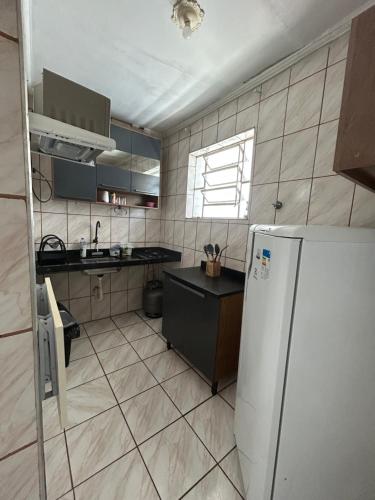 a kitchen with a refrigerator and a sink at Kit Net Santa Cruz in Praia Grande