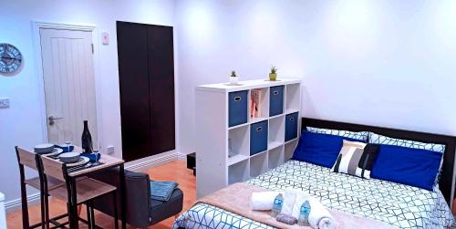 a bedroom with a bed and a table with a chair at Suffolk Cosy Corner with free parking, 10min walking to town centre in Bury Saint Edmunds