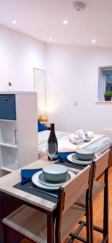 a table with two plates and a wine glass on it at Suffolk Cosy Corner with free parking, 10min walking to town centre in Bury Saint Edmunds