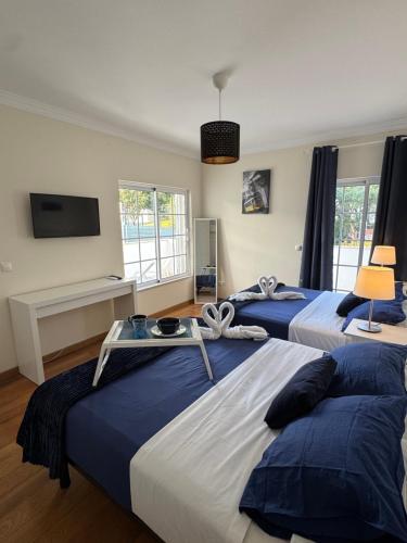a bedroom with two beds and a flat screen tv at Villa Bonita Guesthouse Albufeira Old Town in Albufeira