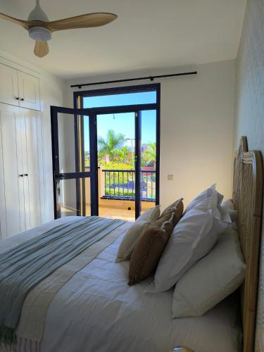 a bedroom with a bed with a view of a balcony at Meloneras Garden Bungalow in Meloneras