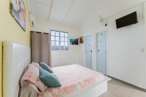 a bedroom with a bed with pillows on it at Studio Les Colibris in Sainte-Anne
