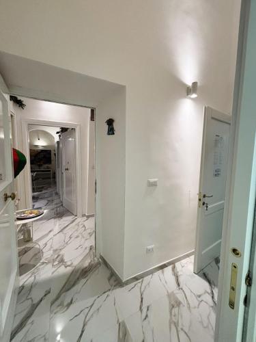 ein Flur mit weißem Marmorboden und einer weißen Tür in der Unterkunft B&B Dei Mercanti in Salerno