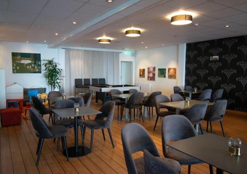 a restaurant with tables and chairs and a piano at Sure Hotel by Best Western City Jonkoping in Jönköping