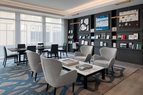 a waiting room with tables and chairs and a library at AC Hotel by Marriott Santa Rosa Sonoma Wine Country in Santa Rosa