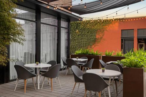 an outdoor patio with tables and chairs and plants at AC Hotel by Marriott Santa Rosa Sonoma Wine Country in Santa Rosa