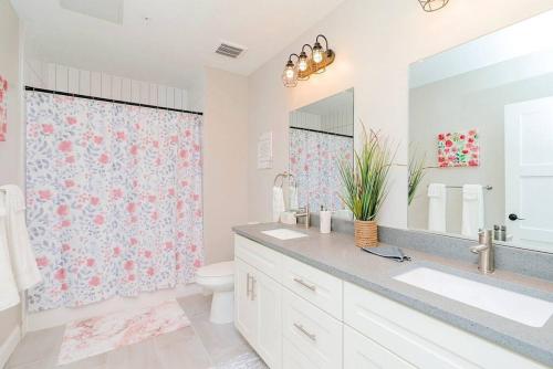 a bathroom with a sink and a toilet and a mirror at Breakfast at Tiffanys Downtown Newport News in Hampton