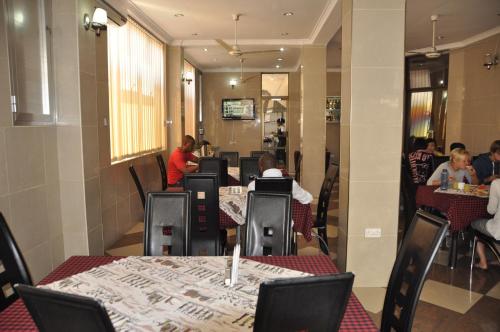 a restaurant with tables and people sitting at tables at Rich Hotel in Arusha