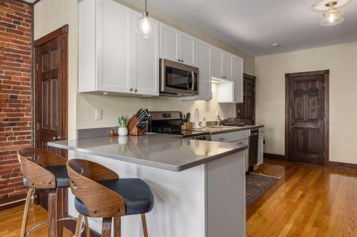 a kitchen with white cabinets and a counter top at Newburyport Flat Downtown Living King Bed in Newburyport