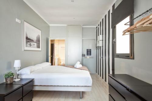 a hotel room with a bed, table, and window at Fira Apartments by gaiarooms in Barcelona