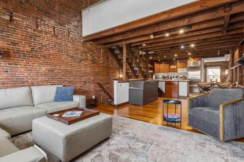 a living room with a couch and a brick wall at City Loft Group Getaway King Downtown Location in Newburyport