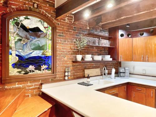 a kitchen with a sink and a brick wall at City Loft Group Getaway King Downtown Location in Newburyport