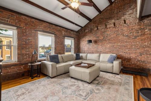 a living room with a couch and a brick wall at City Loft Group Getaway King Downtown Location in Newburyport