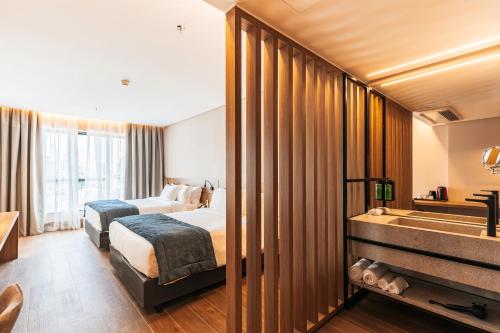 a hotel room with two beds and a bathroom at WTC Goiânia Stay & Hotel by Atlantica in Goiânia