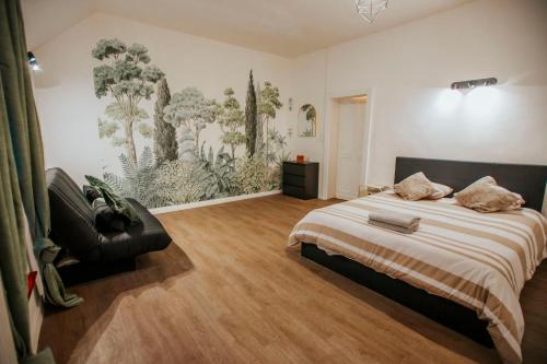 a bedroom with a bed and a painting on the wall at Maison avec jardin - Centre ville de Cambrai in Cambrai