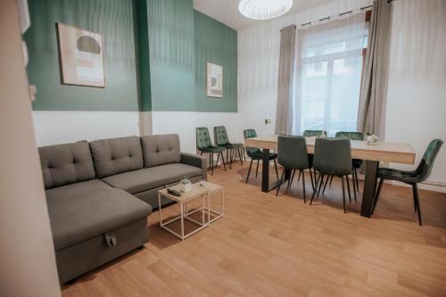 a living room with a couch and a table and chairs at Maison avec jardin - Centre ville de Cambrai in Cambrai