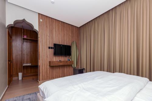 a bedroom with a bed and a flat screen tv at Zawaya watan in Nizwa