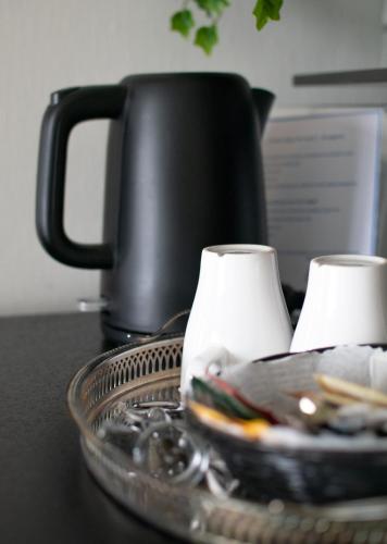 a tray with two cups on a table with a coffee pot at Sure Hotel by Best Western City Jonkoping in Jönköping