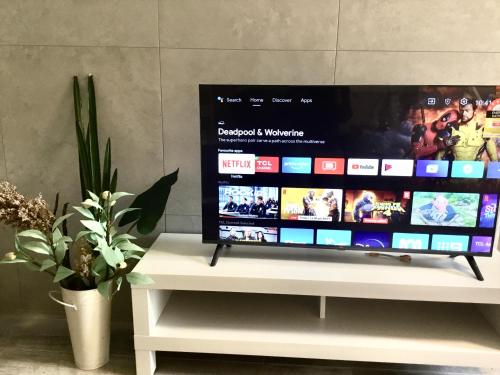 a television on a white stand with a video website at Modern studio, Minutes to Ferry, City, CBD in Sydney