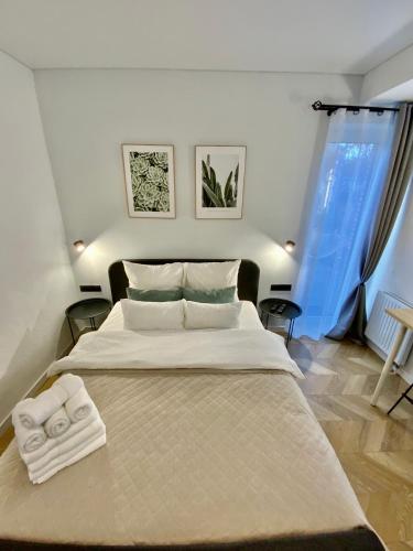 a bedroom with a large bed with towels on it at Salt Garden Apartments in Druskininkai